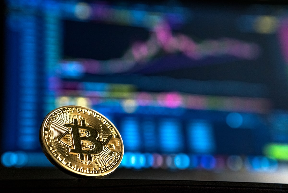 比特幣實體硬幣與加密貨幣市場交易畫面
